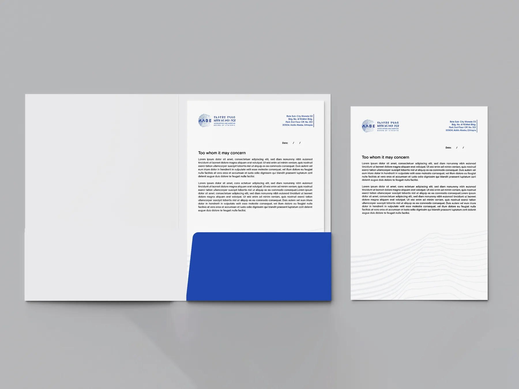 An open AABE presentation folder with a blue pocket, holding the AABE letterhead, beside a second letterhead sheet.