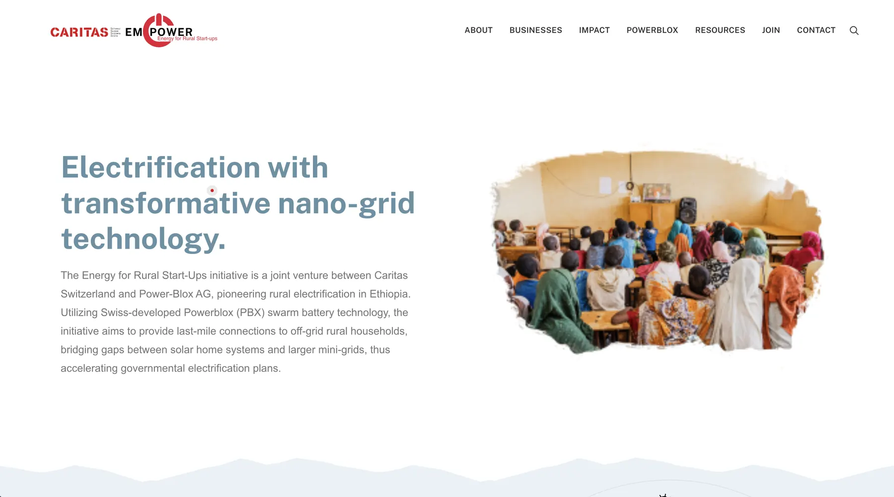 The caritasempower.com home page: the Caritas EMPOWER logo and navigation, the headline Electrification with transformative nano-grid technology, and a photograph of a community screening in a classroom.