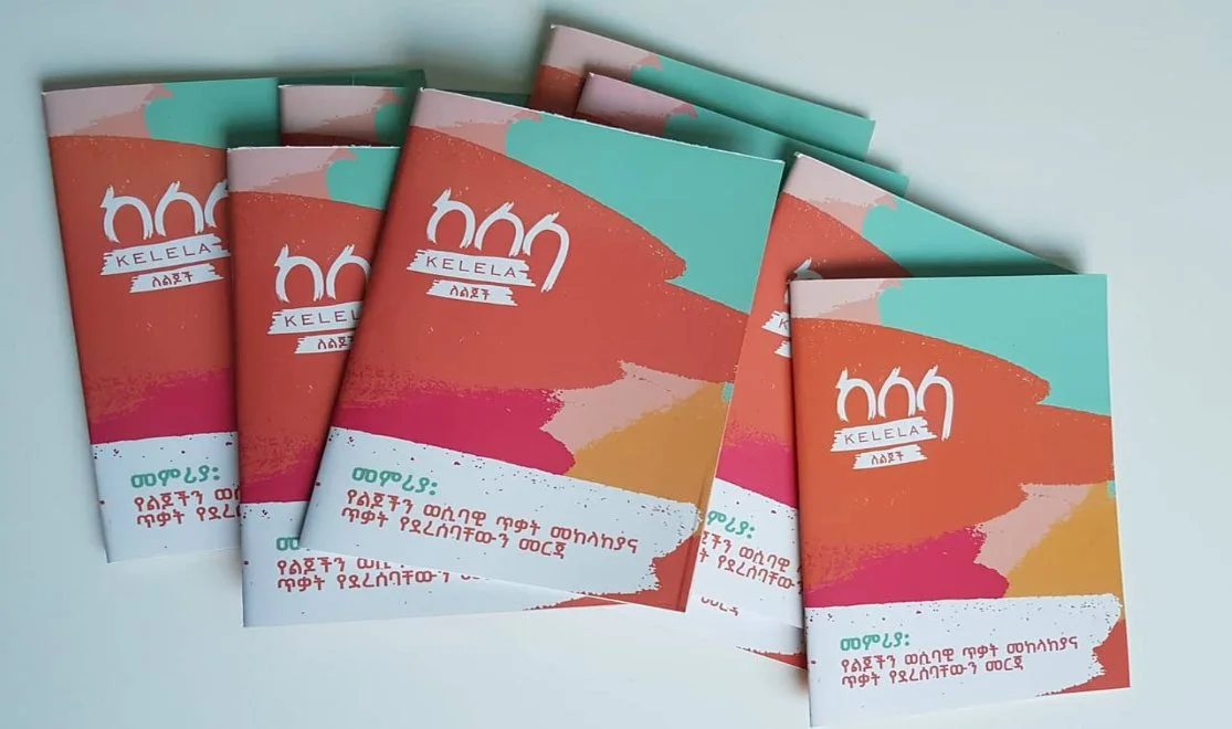 Printed copies of the Amharic edition of the guidebook fanned out on a table.