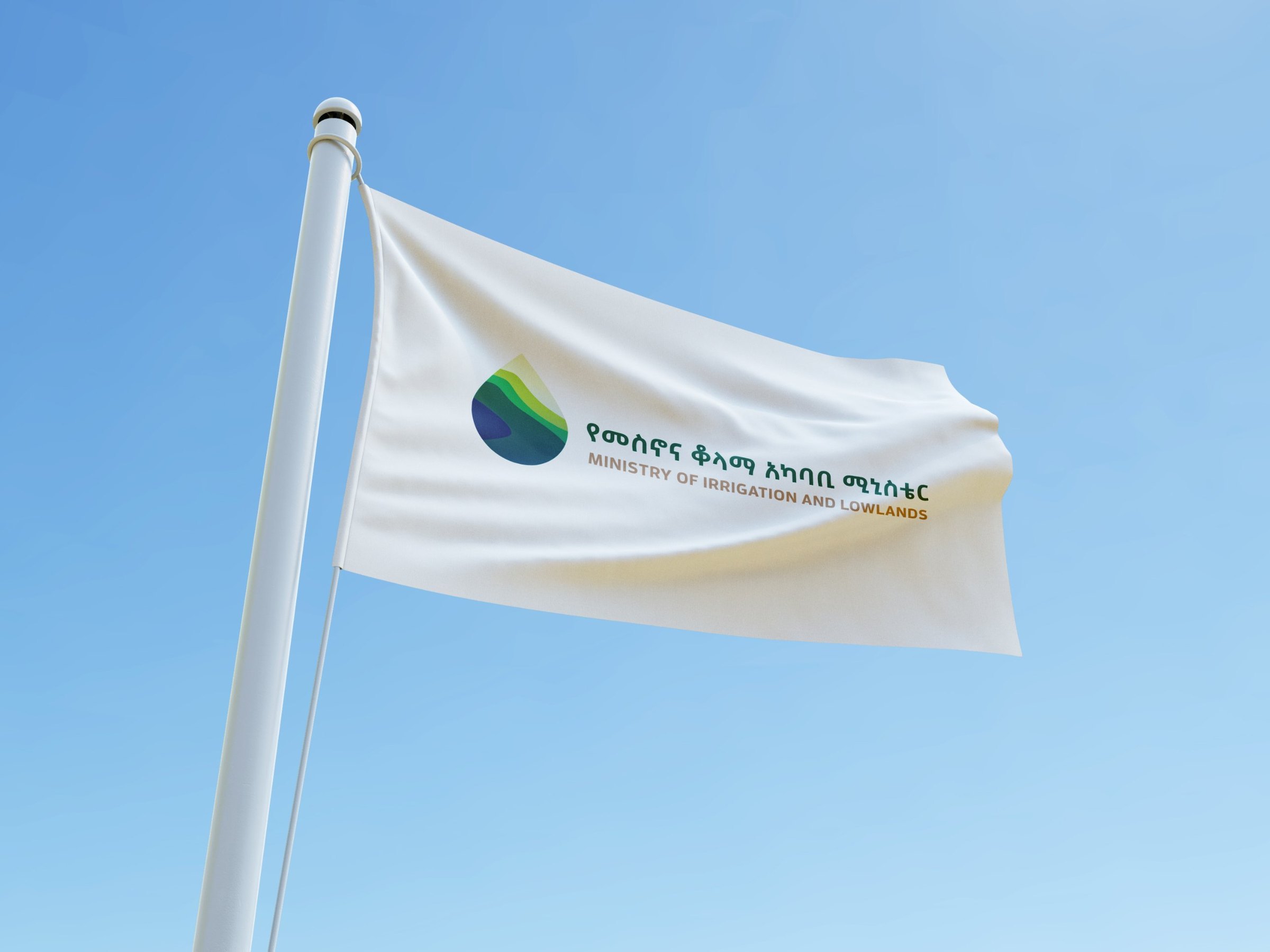 The white MiLLS flag on a flagpole against a clear sky.